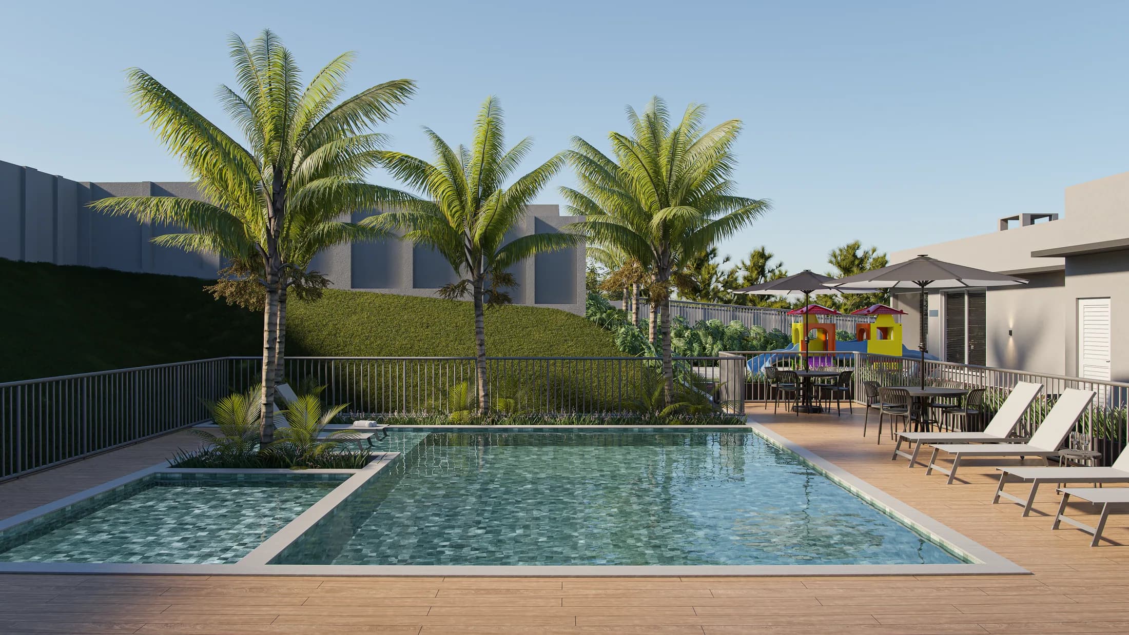 Piscina adulto e infantil do Lumina Residencial com deck de madeira e palmeiras em Foz do Iguaçu